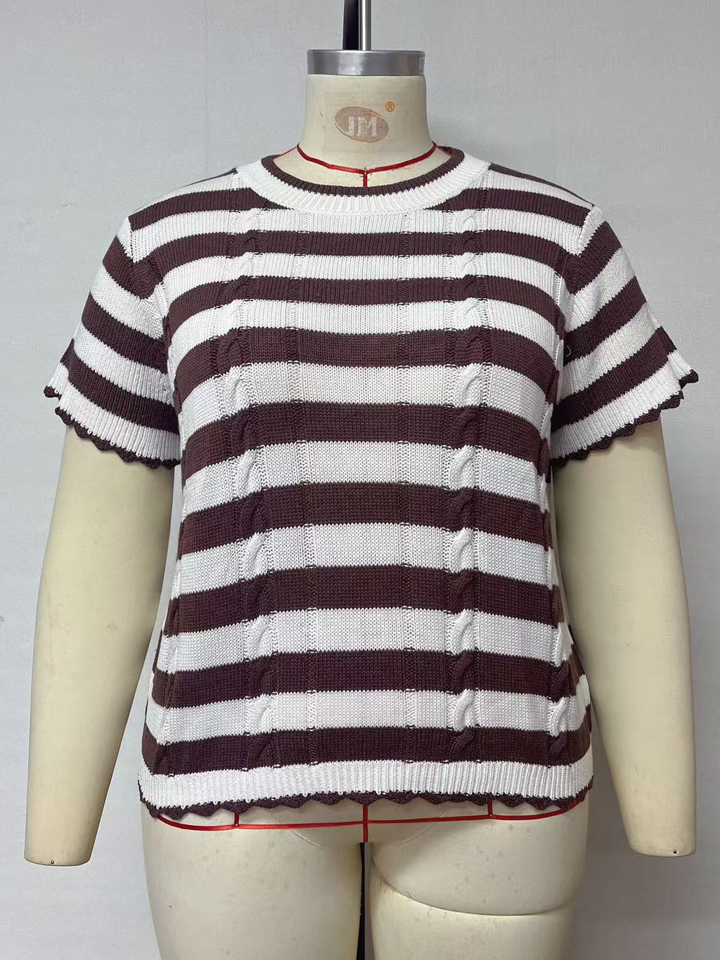 A short-sleeve knit top with horizontal dark brown and white stripes, displayed on a cream-colored dress form mannequin against a plain light gray background.