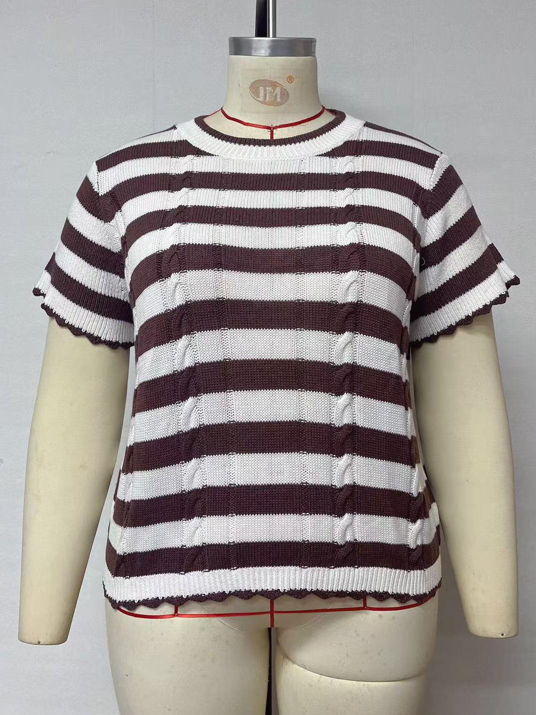 A short-sleeve knit top with horizontal dark brown and white stripes, displayed on a cream-colored dress form mannequin against a plain light gray background.