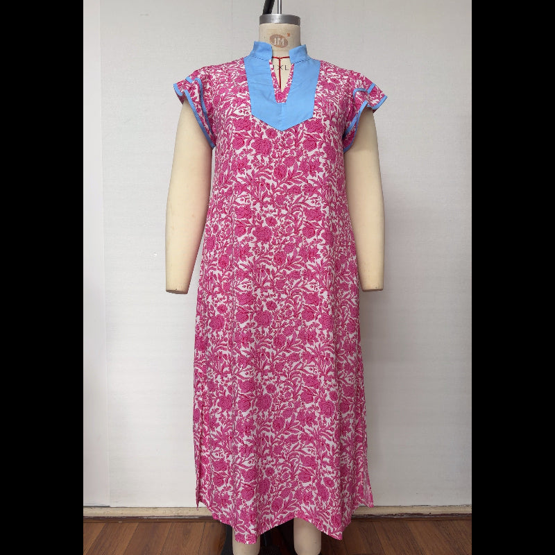 A pink and white floral print dress with a light blue mock neck collar and blue sleeve trim, displayed on a mannequin against a plain white wall.