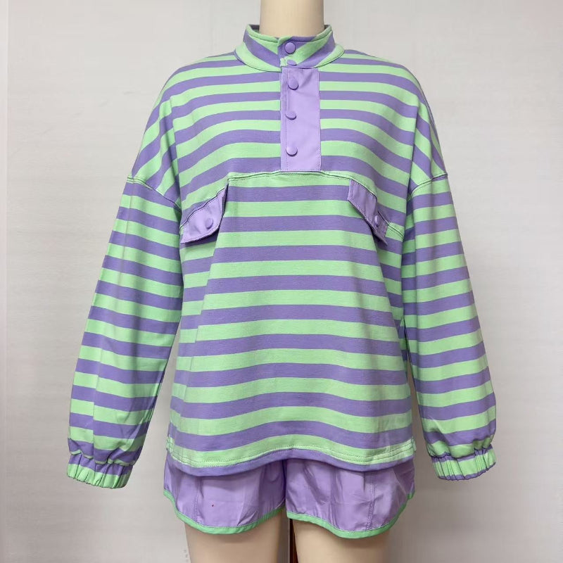 A lavender and light green striped long-sleeve top with a purple mock neck and button placket, displayed on a mannequin with matching purple shorts against a plain light background.