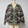 A fuzzy knit cardigan sweater with a camouflage pattern in shades of green, brown, and beige, displayed on a cream-colored mannequin torso against a plain light gray background.