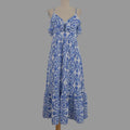A blue and white patterned maxi dress with thin shoulder straps and a ruffled bodice, displayed on a beige dress form against a plain light gray background.