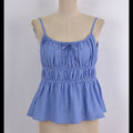 A light blue and white gingham patterned camisole top with a smocked waist and tie neckline, displayed on a beige fabric dress form against a white background.