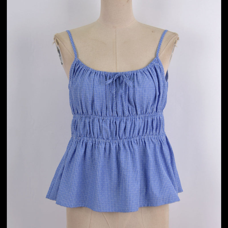 A light blue and white gingham patterned camisole top with a smocked waist and tie neckline, displayed on a beige fabric dress form against a white background.