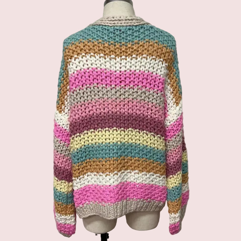 Colorful striped sweater on a mannequin against a plain background