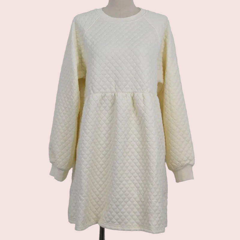 An off-white quilted long-sleeve dress displayed on a mannequin against a plain light gray background.