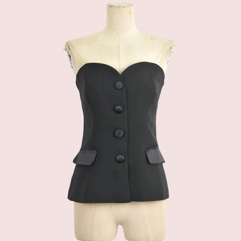 A black strapless corset-style top with a sweetheart neckline, four front buttons, and two flap pockets, displayed on a cream dress form against a white background.