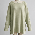 A light sage green ribbed knit sweater with elbow patches and a wide boat neckline, displayed on a cream dress form mannequin against a neutral gray background.