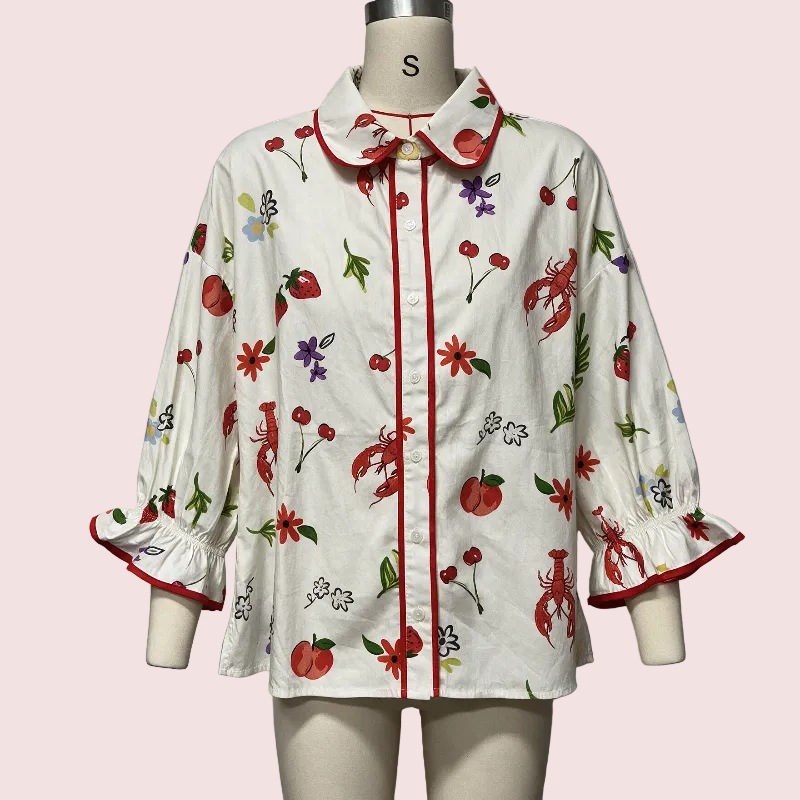 A white long-sleeve button-up shirt with a colorful lobster and cherry print, displayed on a mannequin. The shirt features red trim along the collar, placket, and sleeve cuffs.