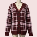 A women's knit cardigan sweater displayed on a cream mannequin torso. The cardigan features a maroon and pink plaid pattern with white grid lines, a V-neck, and dark brown buttons.