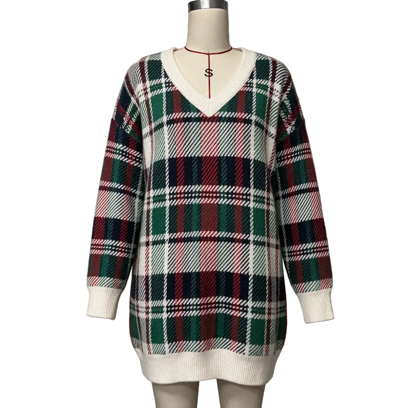 A long-sleeve V-neck knit sweater displayed on a mannequin torso against a plain light gray wall. The sweater has an allover plaid pattern with cream, dark green, red, and black stripes, with solid cream ribbed trim at the collar, cuffs, and hem.