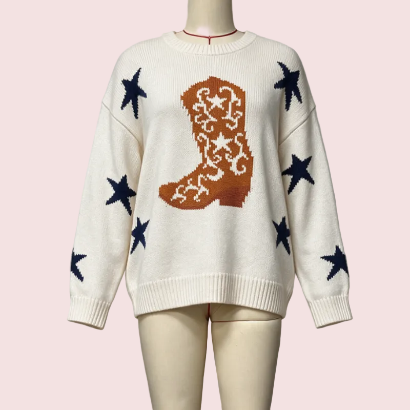 An off-white knit sweater displayed on a mannequin, featuring a large brown cowboy boot motif with white star details on the chest and scattered dark navy blue stars on the sleeves and body.