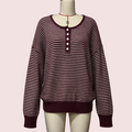 A long-sleeve knit sweater with horizontal burgundy and off-white stripes, featuring a buttoned henley neckline, displayed on a mannequin torso against a plain light gray background.