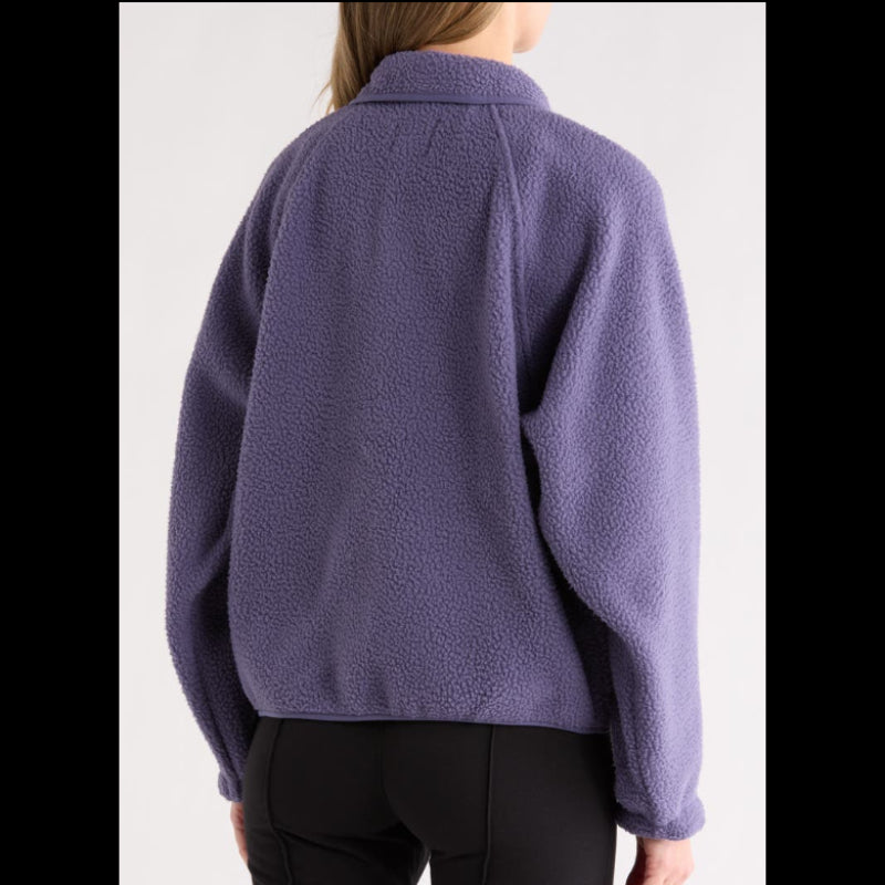 Person wearing a purple fleece jacket on a plain background