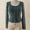 A long-sleeve scoop-neck top in a muted teal blue-green color, displayed on a cream-colored dress form mannequin against a neutral beige background.