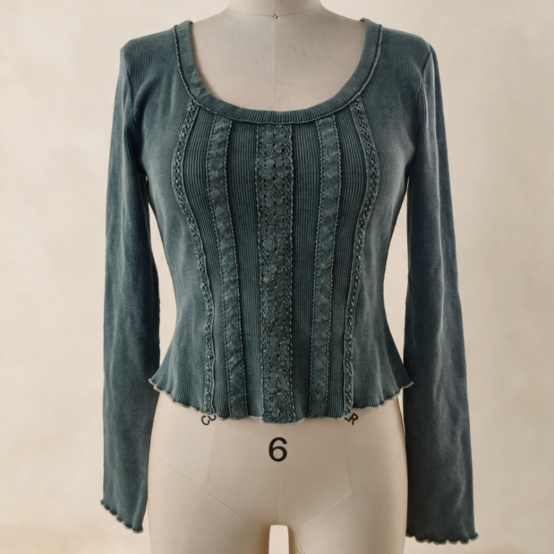 A long-sleeve scoop-neck top in a muted teal blue-green color, displayed on a cream-colored dress form mannequin against a neutral beige background.